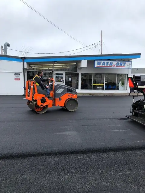 Roller finishing a parking lot at a commercial building
