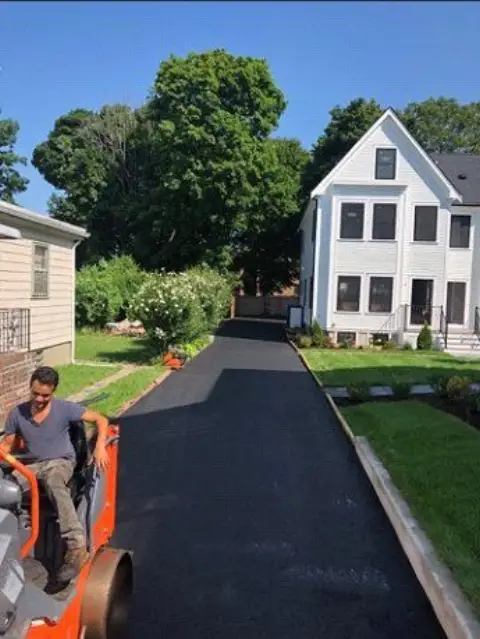 Long driveway paved beside a white house