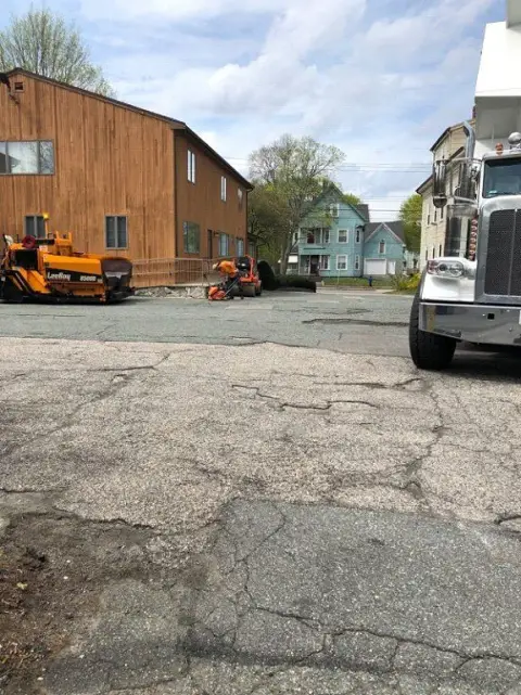 Paver and truck working on a cracked lot