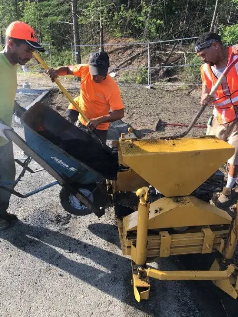 Crew loading an asphalt paver